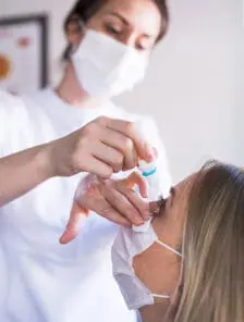 Ophthalmologist giving patient medicine