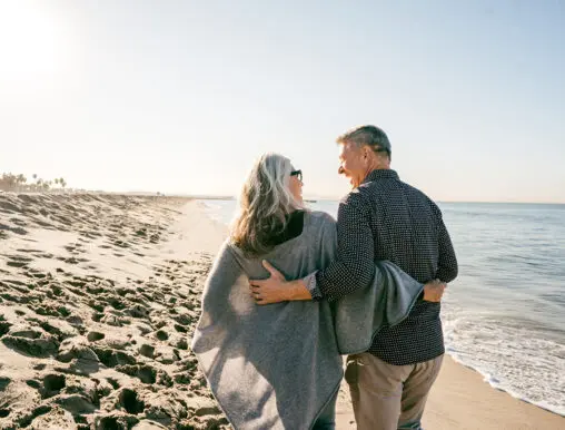 Happy senior couple walking the beach together