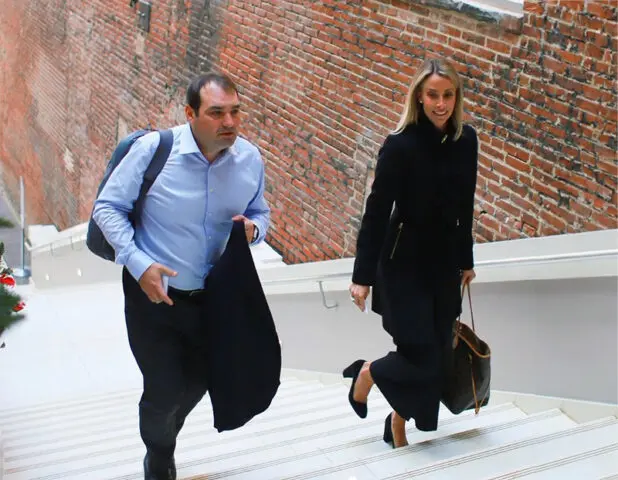 Man and woman walking up stairs next to a brick wall